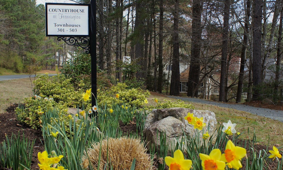 Signpost for Countryhouse surrounded by flowers and landscaping